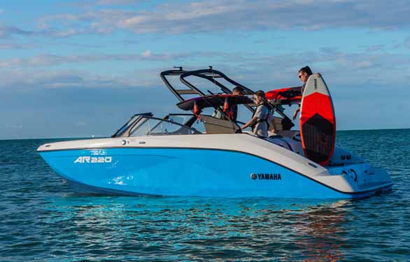 Yamaha jet propulsion boat with man standing on it with a wake-board