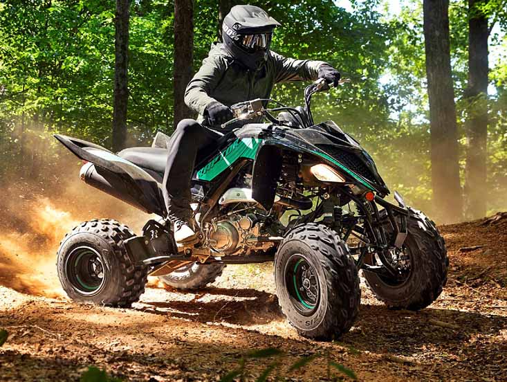 Person on a Yamaha Raptor kicking up sand and dirt having fun