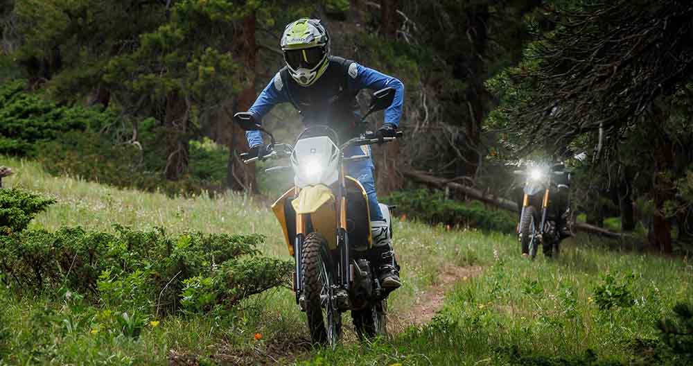 Pair of Suzuki bold yellow bikes riding off road trails