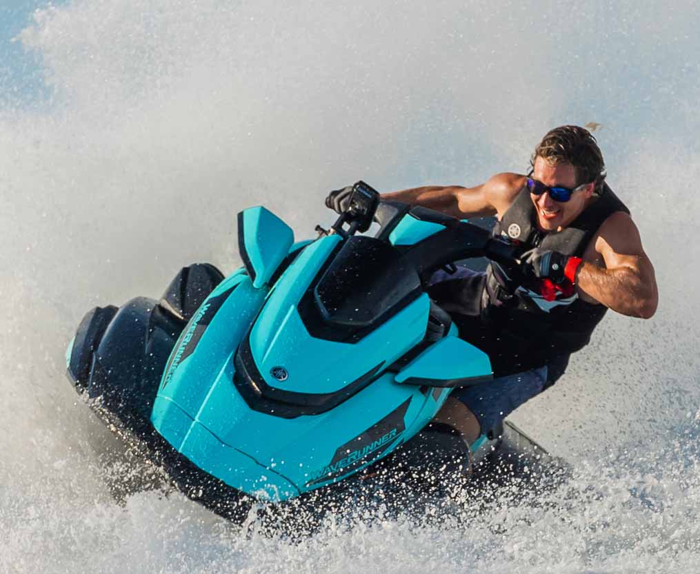Man on a Yamaha Waverunner going fast and creating waves with splashes out in the ocean