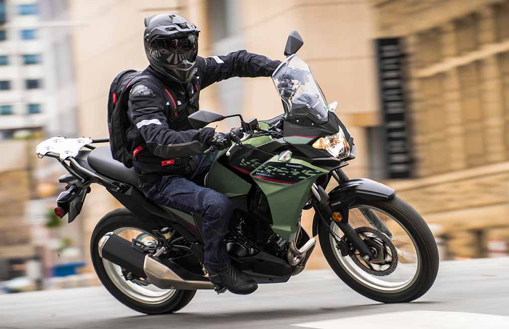 Kawasaki Versys Motorcycle rider with a helmet on making a smooth corner turn