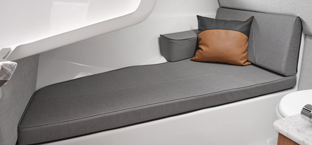 Comfortable interior cabin on the Yamaha 295 Series featuring a cushioned bench with accent pillow and modern finishings.