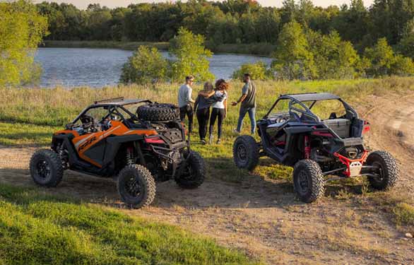 Couples hanging out next to there Polaris RZR's